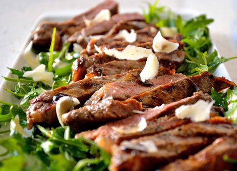 Sliced beef on rocket with Grana cheese scales